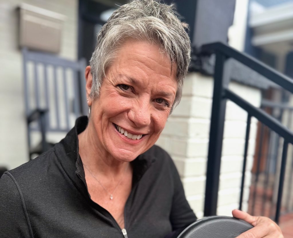 Photo of Wendy Valerio playing a drum.